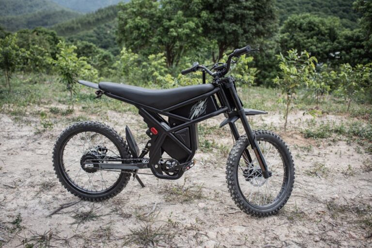 Electric dirt bike parked in a lush, hilly forest area, capturing an adventurous and eco-friendly travel vibe.