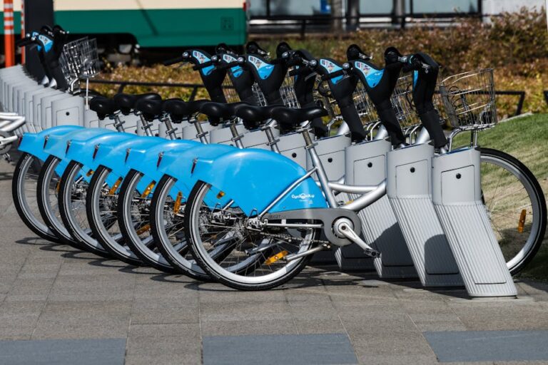 A row of blue rental bicycles parked in an urban area of Toyama City, Japan.