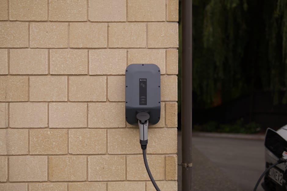 A wall-mounted electric vehicle charging station installed on a brick wall in Christchurch, New Zealand.