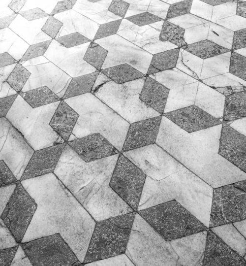 Intricate marble tiles in a geometric 3D star pattern for a modern aesthetic.