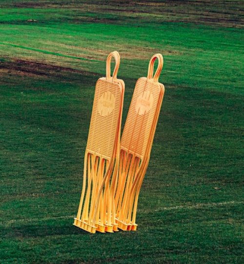 Bright orange soccer training dummies on a vivid green football field.